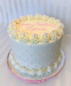 a birthday cake with white frosting and pink decorations