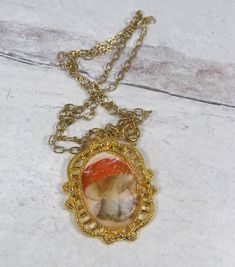 Sweet woodland mushroom pendant. Image of a red mushroom with white dots is set in a vintage style gold plated pewter setting. Sealed in resin for a glass like appearance. Lead and nickel free gold plated chain. 17 5/8" end to end. Pendant hangs an additional 1.5". Vintage Red Resin Jewelry, Red Cameo Necklace For Gift, Vintage Gold Resin Jewelry, Retro Resin Jewelry Gift, Retro Resin Jewelry For Gifts, Retro Glass Necklace For Gifts, Vintage Gold Necklace With Pressed Flowers, Vintage Resin Necklace As Gift, Vintage Resin Necklace For Gift