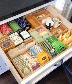 an open drawer filled with lots of different items on top of a white countertop