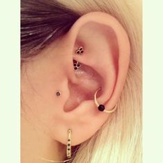 a woman's ear with two piercings on it