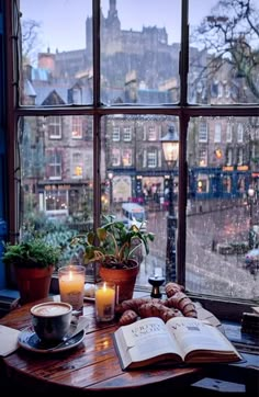 an open book sitting on top of a table next to a window