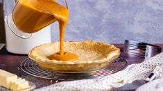 someone pouring caramel sauce into a pie crust