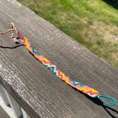 a multicolored rope is on top of a wooden bench