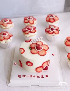 cupcakes with white frosting and strawberries are arranged on a plate next to each other