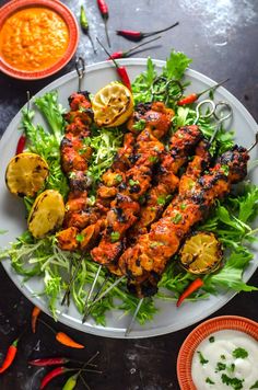 grilled chicken skewers on a bed of lettuce and lemons