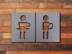 two metal signs on a wooden wall with coffee cup and spoons in the shape of man and woman