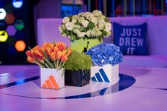 three vases filled with flowers sitting on top of a table