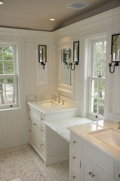 a large bathroom with double sinks and two mirrors on the wall, along with three windows