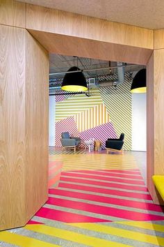 an open room with colorful carpeting and wooden partitions on the wall to let light in