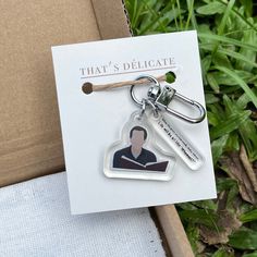 a keychain with an image of a man in a book on it and the words that's delicate