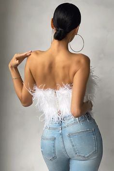 a woman in high waist jeans with feathers on her back