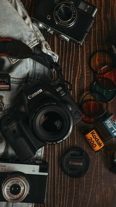 a camera, lens and other items on a wooden table next to each other for photography