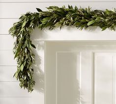 a white door with a green wreath hanging on it's side next to the front door