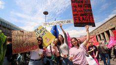 some people holding signs and standing in the street