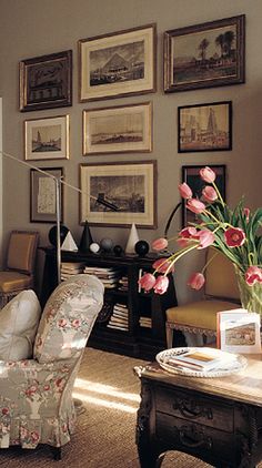 a living room filled with furniture and pictures on the wall