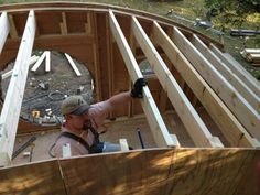 a man standing on top of a wooden roof