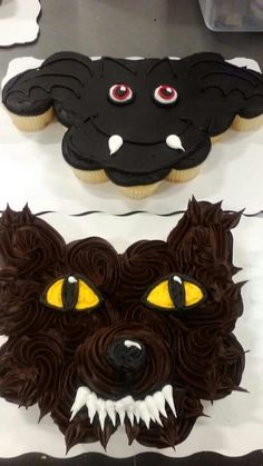 two cakes decorated with black icing and yellow eyes