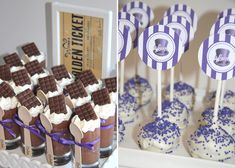 desserts are displayed on sticks with purple and white decorations