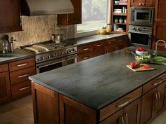 a kitchen with wooden cabinets and stainless steel appliances, including an island in the middle