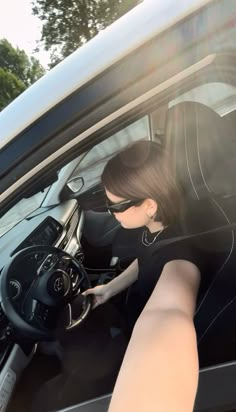 a woman sitting in the driver's seat of a car