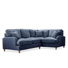 a blue sectional couch with pillows on the back and armrests, in front of a white background