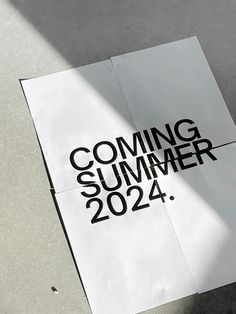 a piece of paper with the words coming summer 2012 on it sitting next to a skateboard