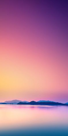 an airplane is flying in the sky over water at sunset with mountains in the background