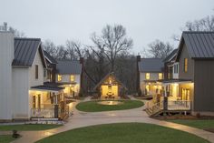 a row of houses lit up at night with lights on the porchs and windows