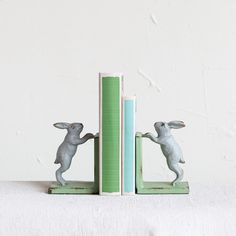 two bookends made to look like rabbits are holding each other's hands