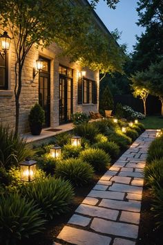 an outdoor walkway lit up with lights and plants in front of a house at night