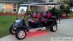 a black and red golf cart parked in front of a house