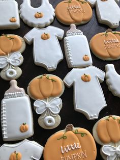 baby shower cookies decorated like pumpkins and onesuits with name written on them