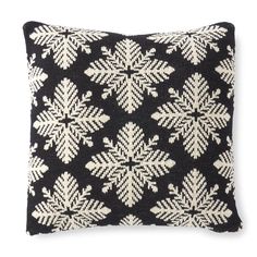 a black and white pillow with snowflakes on it