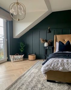 a bedroom with dark green walls and white bedding in the corner, along with a large window