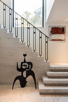 an artistically designed sculpture stands in front of the staircase leading up to the second floor