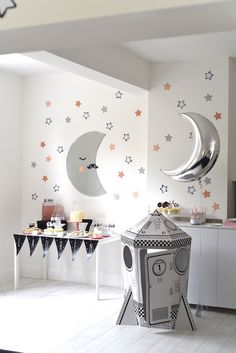 a child's room decorated in white and black with stars, moon and crescent wall decals