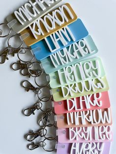 a bunch of key chains that have different types of letters on them, all in different colors