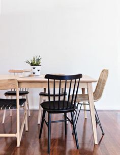 a wooden table with four chairs and a potted plant sitting on top of it