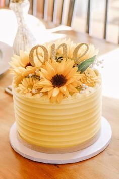 a yellow cake with sunflowers and the number 60 on top is sitting on a table