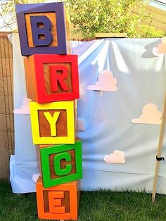 the letters are made out of wooden blocks and placed on top of each other in front of a backdrop