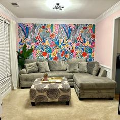 a living room with two couches and a coffee table in front of a colorful wall