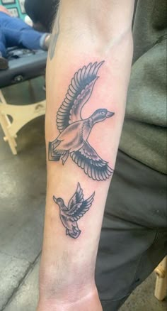 a man's arm with two birds on it