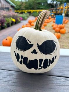 a pumpkin decorated with the face of a jack - o'- lantern is sitting on a porch