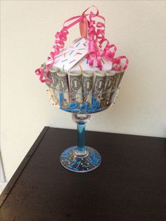 a birthday cake sitting on top of a glass vase filled with confetti and candy