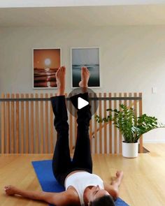 a woman is doing yoga on a mat in the middle of a room with wooden floors