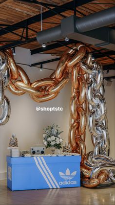 a large balloon arch in the middle of a room with an adidas logo on it