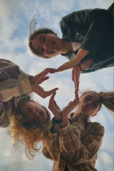 three girls are standing in the middle of a circle with their hands on each other