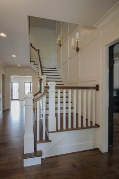 a staircase in a house with white walls and wood floors