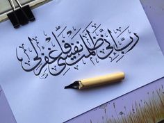 a pen is laying on top of a piece of paper that has been written in arabic