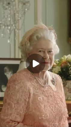 an old woman sitting at a table with flowers in the background